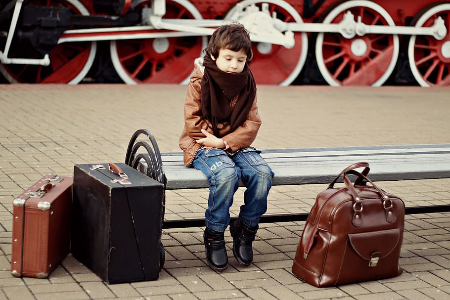 boy in brown jacket and blue jeans sitting on bench, station HD wallpaper