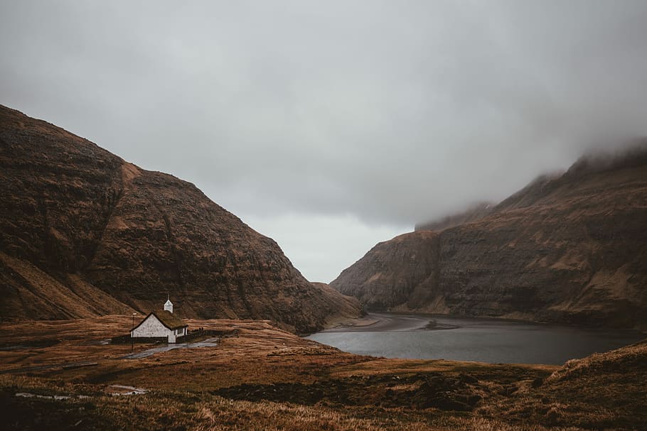 house beside mountain, white concrete house near mountain and lake under gray skies HD wallpaper