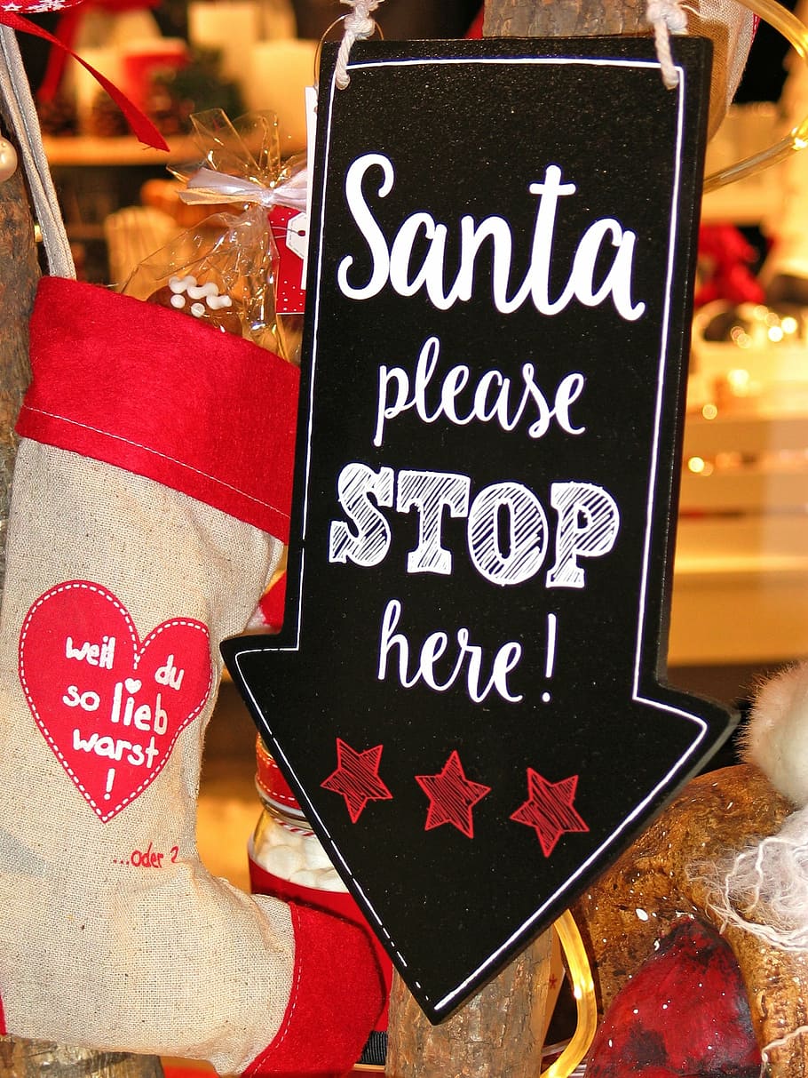 Santa Please Stop Here signage beside christmas stocking, christmas time