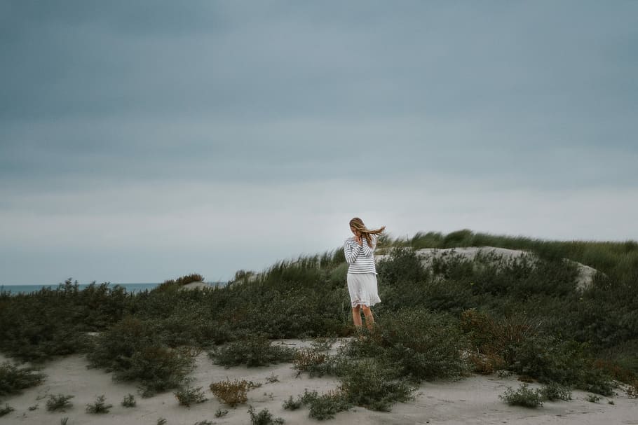 woman standing near green bush at daytime, woman standing on sand near ocean HD wallpaper