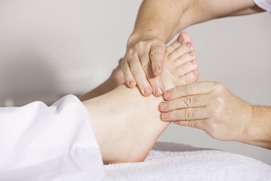 person massaging another person's right foot, physiotherapy, foot massage