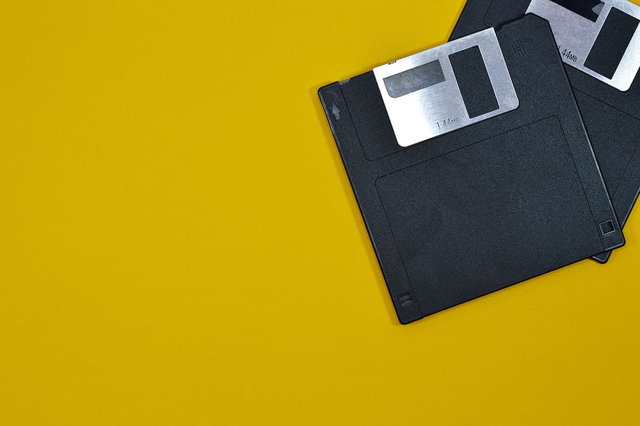 two black floppy discs on yellow surface, memory, magnetic, floppy disk