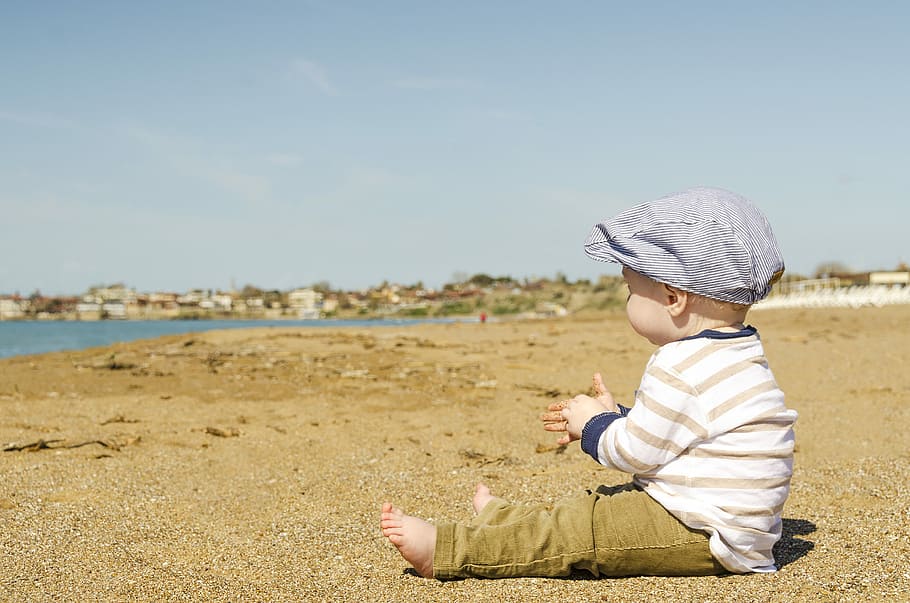 sitting toddler on seashore at daytime, boy sitting on brown sand near the body of water during daytime, HD wallpaper