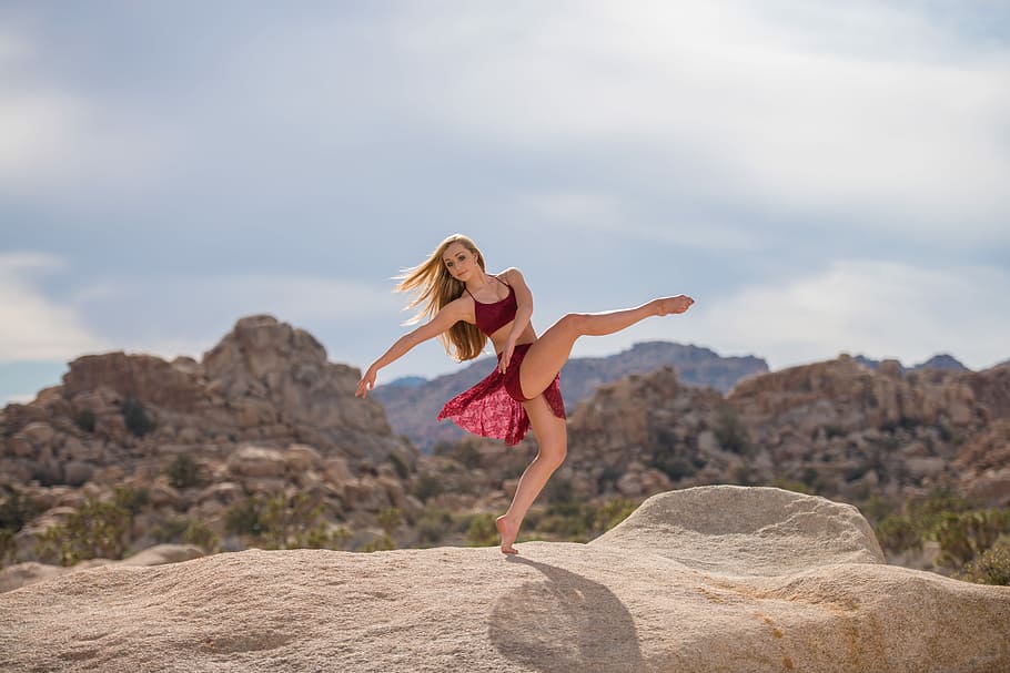 woman dancing on brown hill during daytime, woman standing on brown rock formation in dance form HD wallpaper