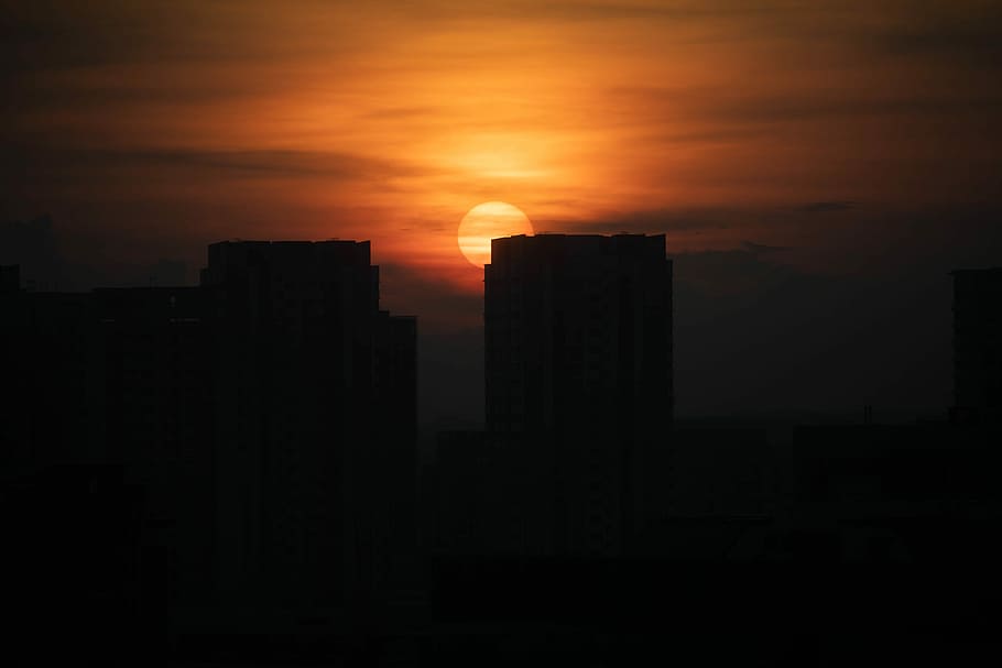 city buildings and sunset, silhouette of buildings under cloudy sky photo taken during sunset HD wallpaper