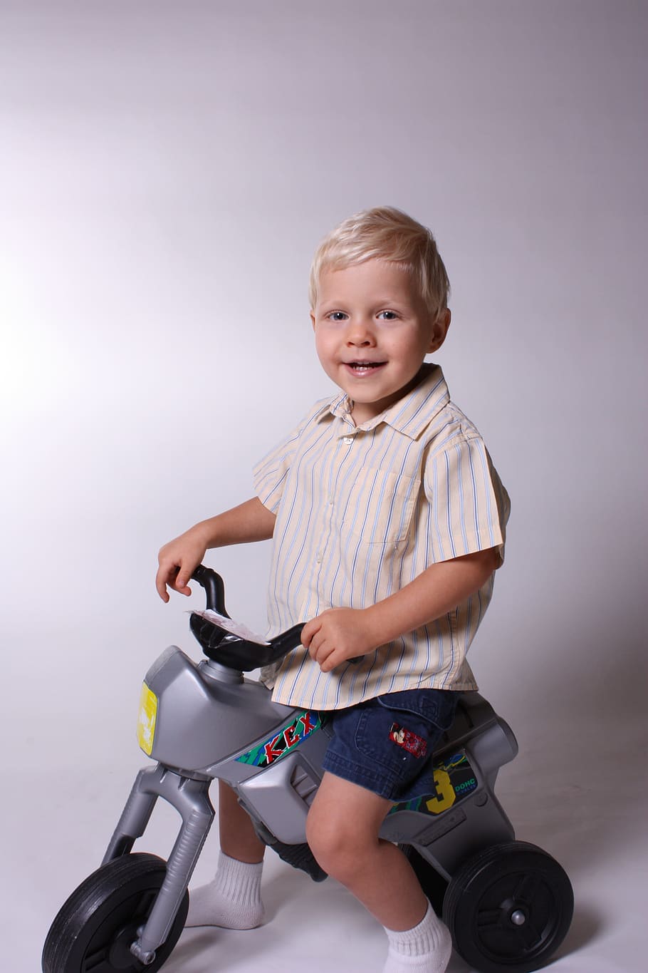 smiling boy riding trike close-up photography, kids, playing