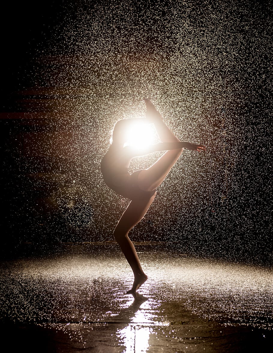 woman dancing in the rain, woman dancing against the light, water