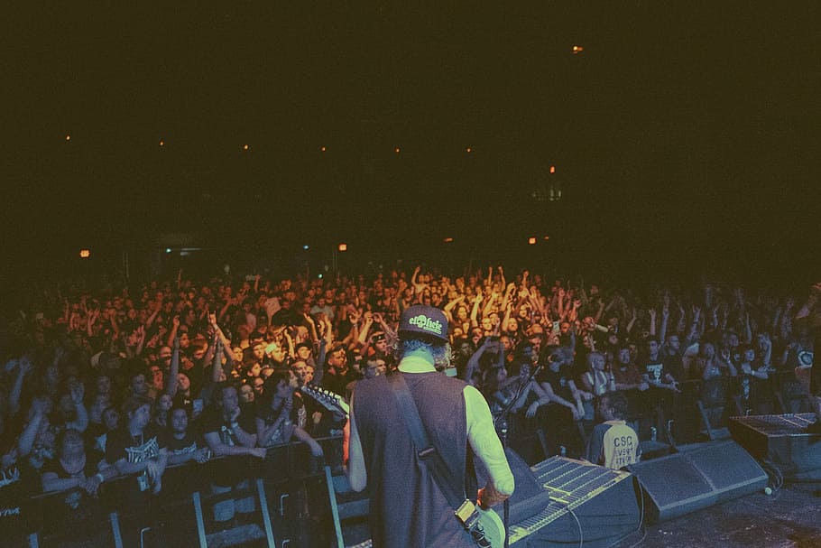 man holding white electric guitar in front of crowd of people, man playing guitar in front of people HD wallpaper