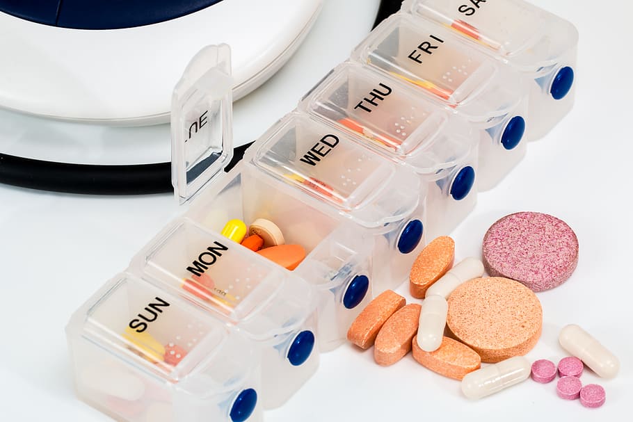 assorted medicine pills in clear medicine organizer, blood pressure