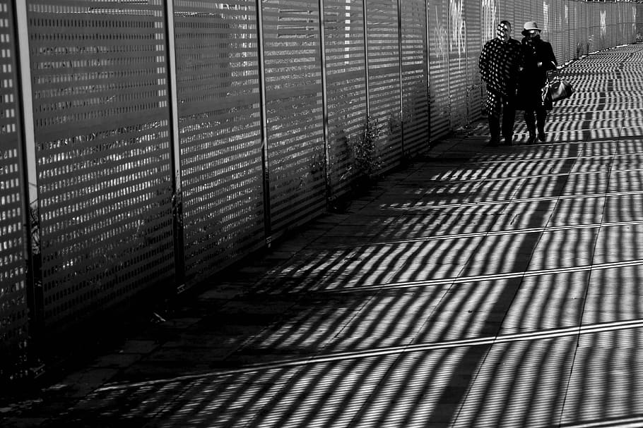 man and woman walking beside fence grayscale photography, Couple