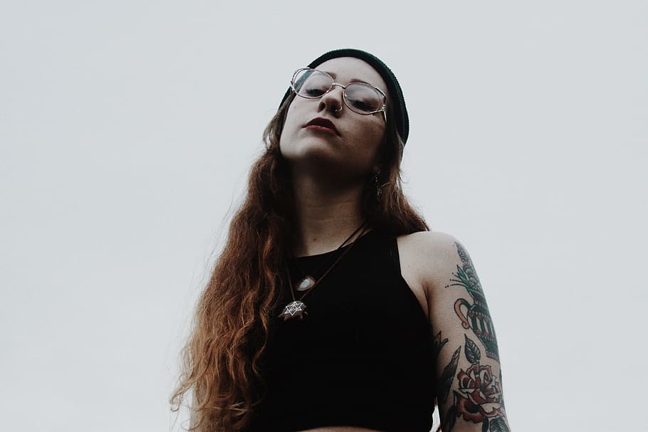 woman in black tank top wearing eyeglasses, woman wearing black sleeveless top and wearing eyeglasses looking down