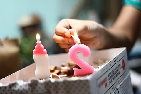 person lighting number 2 candle, person holding brown match stick HD wallpaper