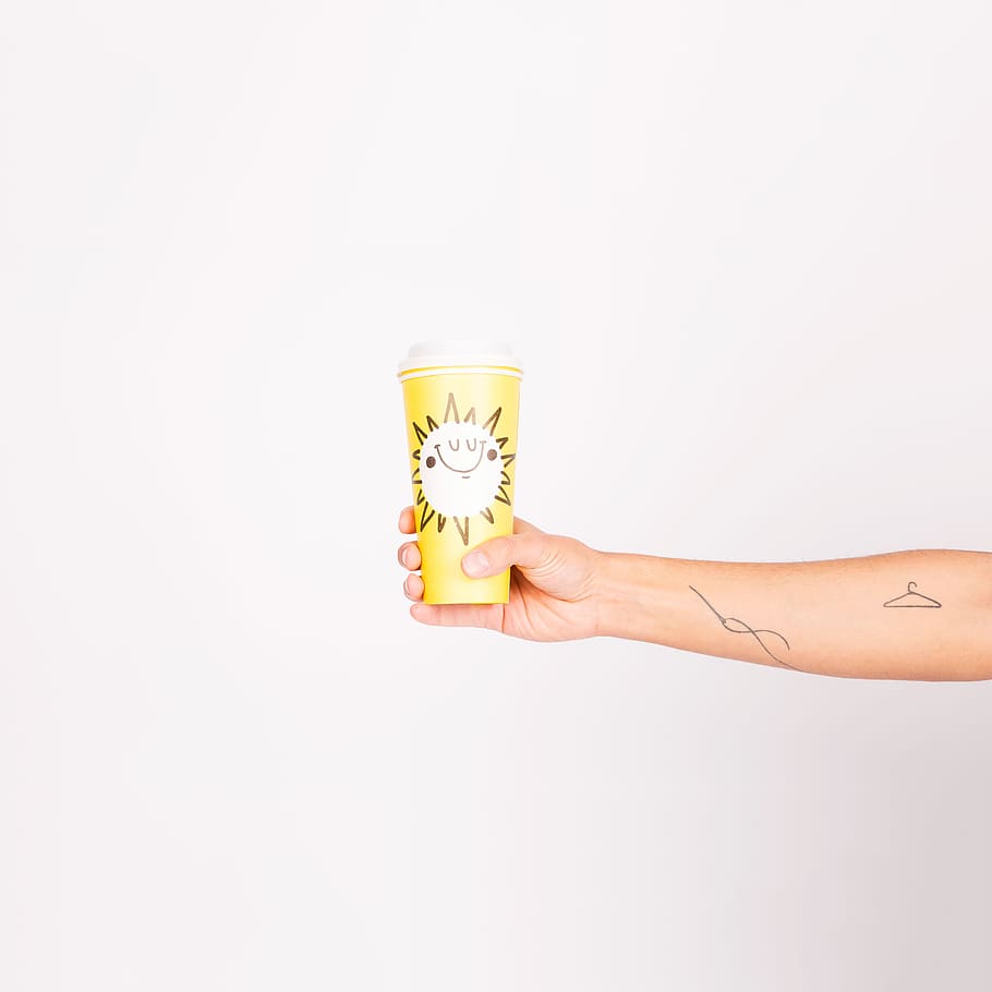 person holding yellow drinking cup, person with tattoos holding yellow disposable cup HD wallpaper