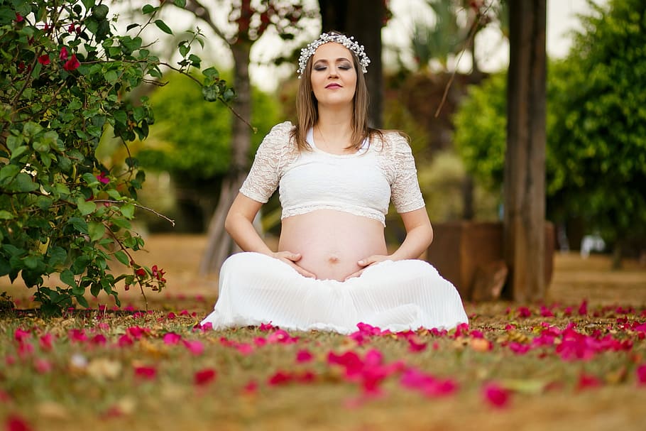 woman wearing white crop top and white skirt sitting on green grass with petals HD wallpaper