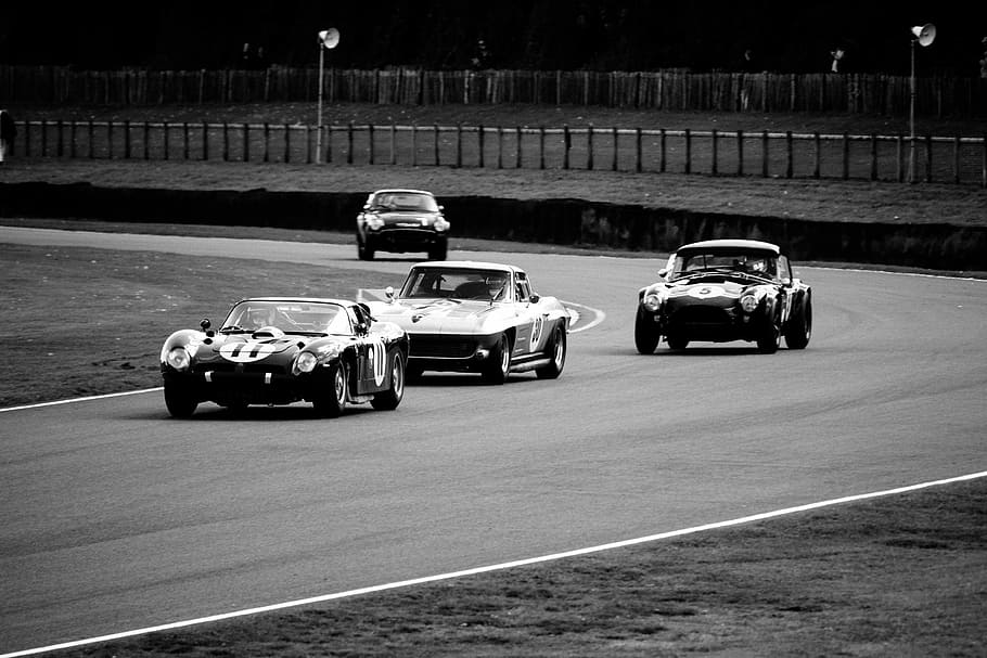 grayscale photo of of four cars racing on race track, grayscale photogray of four assorted cars