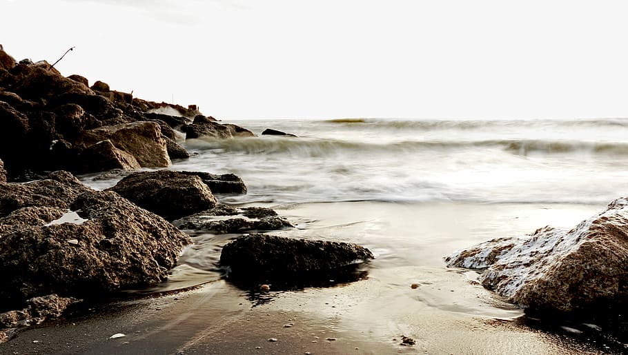 view of rock formation on seashore during daytime, time-lapse photo of waves crashing on rocks HD wallpaper