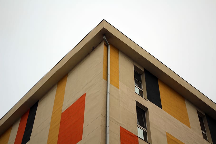 beige and red concrete building facade, low-angle beige concrete building under white sky during daytime HD wallpaper