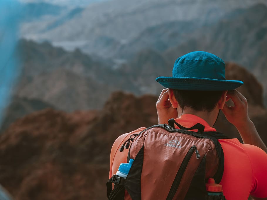 man wearing backpack facing the mountains during day, man wearing backpack on mountain HD wallpaper
