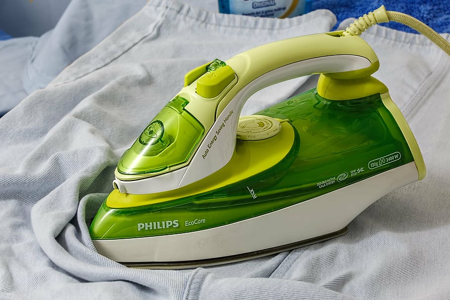 green and white Philips EcoCare clothes iron on white textile
