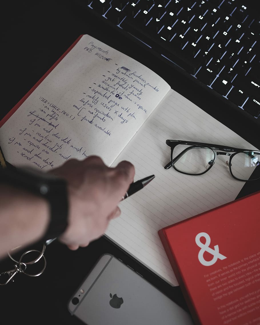 eyeglasses on white notebook, person holding pen and notebook HD wallpaper