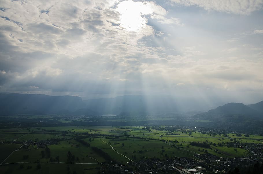 aerial photography of rays on field at daytime, city under cloudy sky HD wallpaper