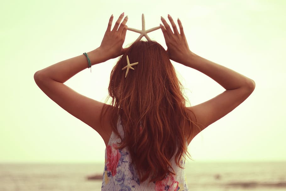 selective focus photography of woman holding white star fish on head HD wallpaper