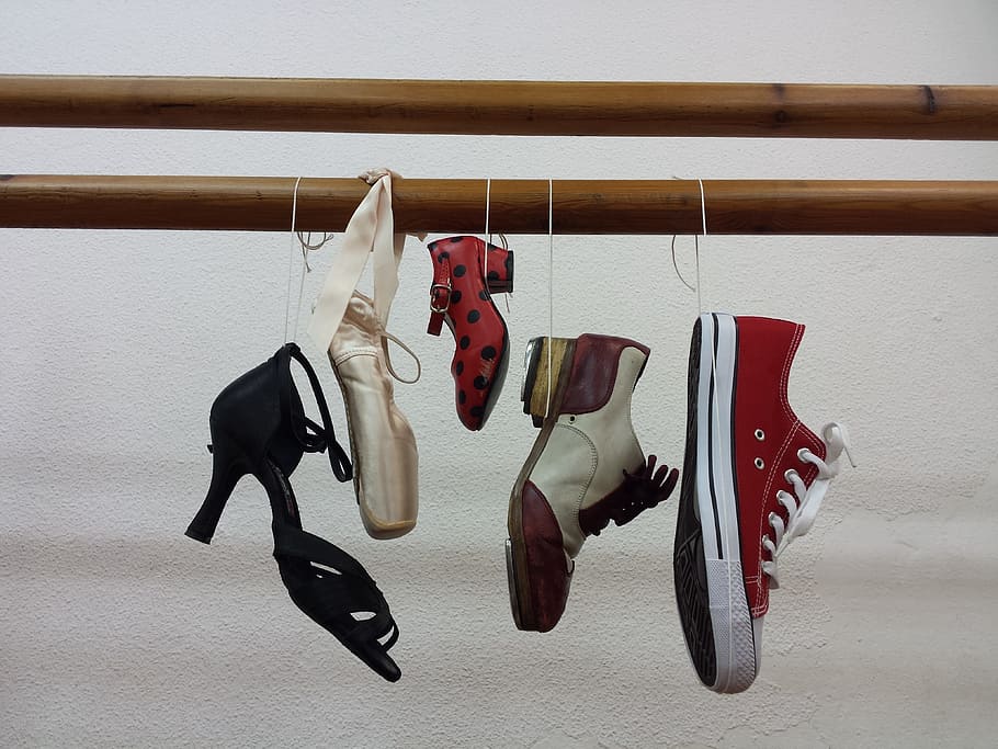 five assorted footwears hang on bamboo shallow focus photography