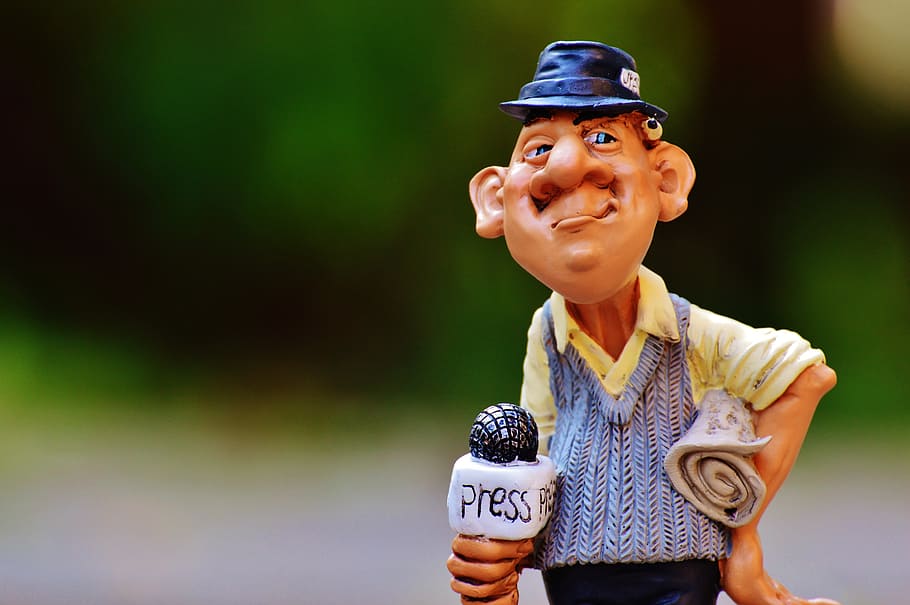 shallow focus photography of man figurine, journalist, press