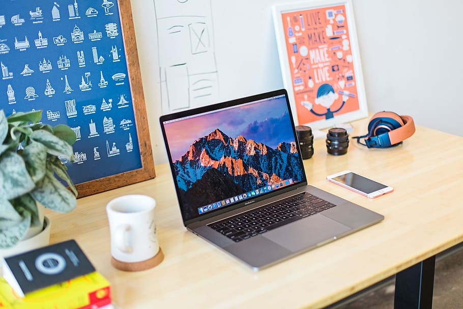 turned on MacBook Pro beside white ceramic mug, MacBook Pro on top of table, HD wallpaper