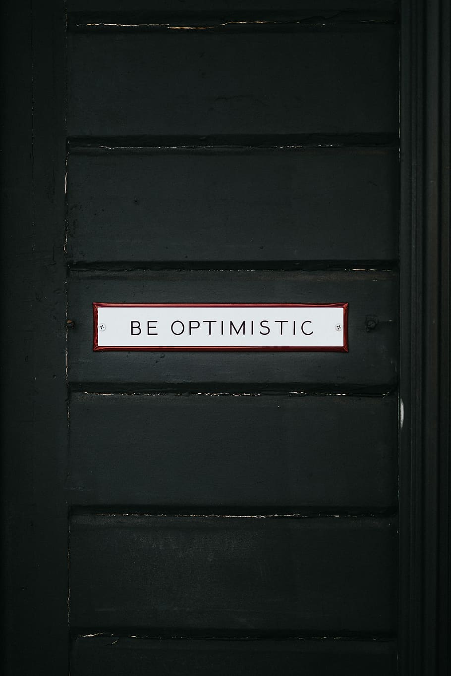 black wooden door with be optimistic text overlay, black wooden door with white Be Optimistic signage, HD wallpaper