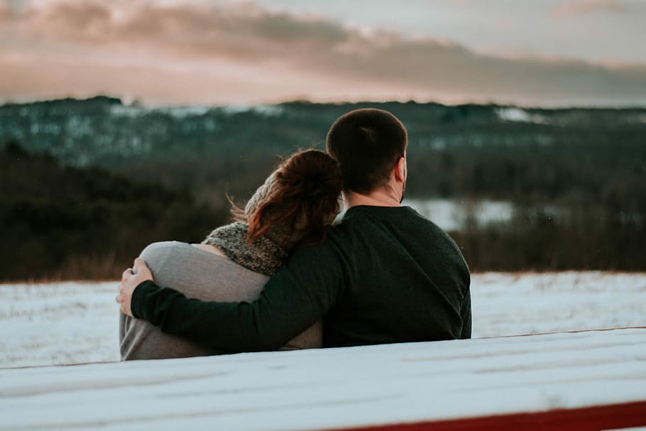 man and woman sitting on bench during daytime, man holding woman while sitting on bench HD wallpaper