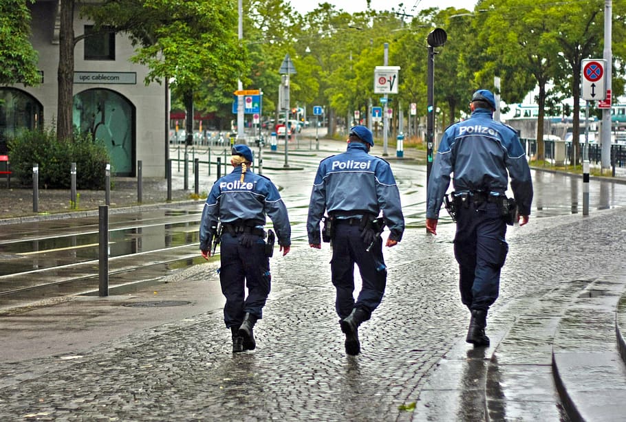 three Police officers walking on black road, city, street, law