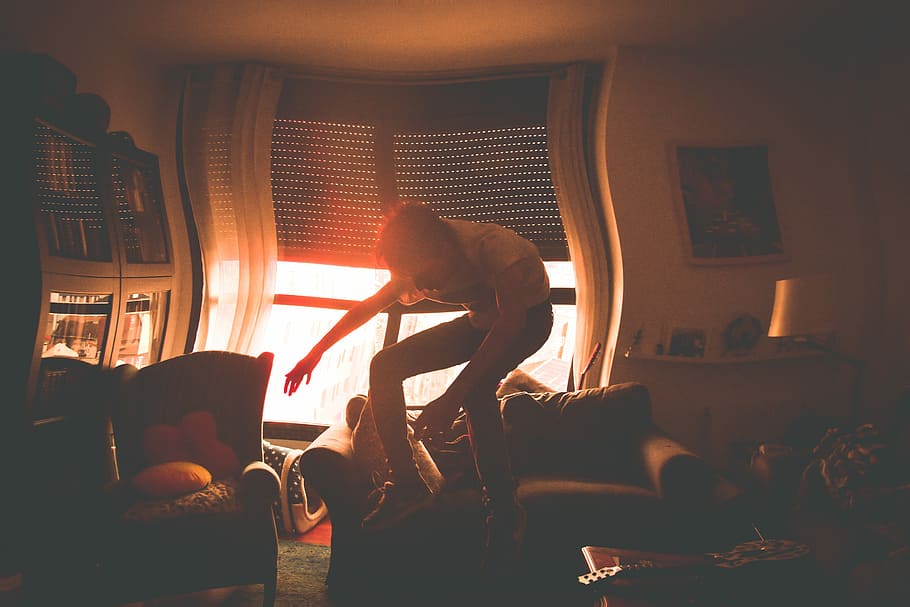 person jumping near sofa, man jumping beside sofa, sun, window HD wallpaper