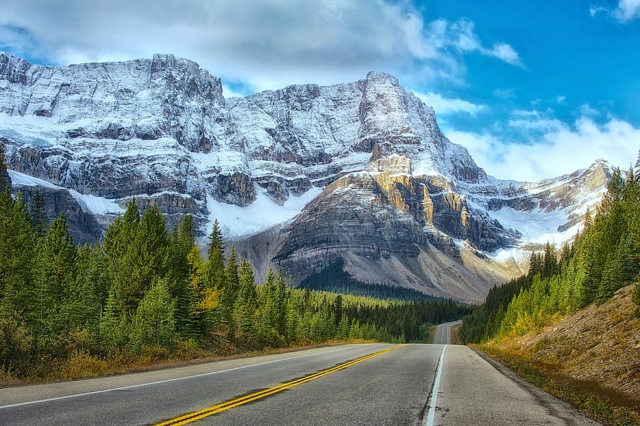 landscape photography of concrete road near the mountains, road with snow covered mountains HD wallpaper