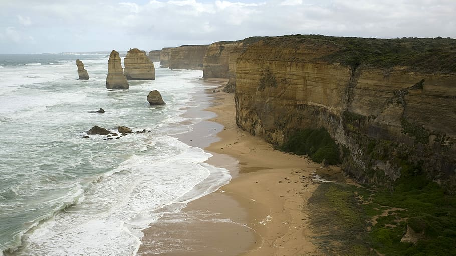 12 Apostles, body of water near brown rocky mountains, beach HD wallpaper