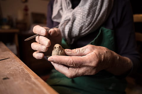 person holding bird wood craft, person holding a brown wooden bird HD wallpaper