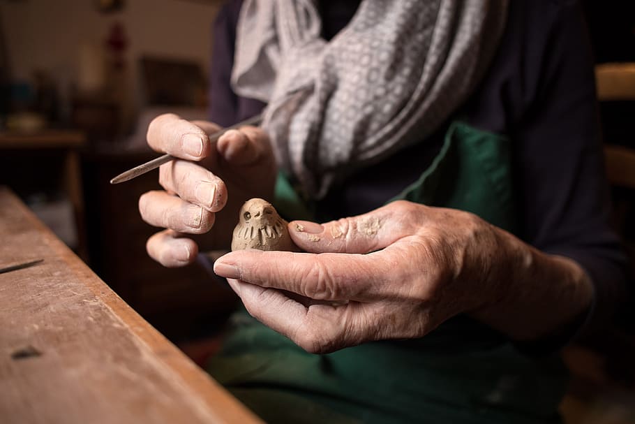 person holding bird wood craft, person holding a brown wooden bird HD wallpaper