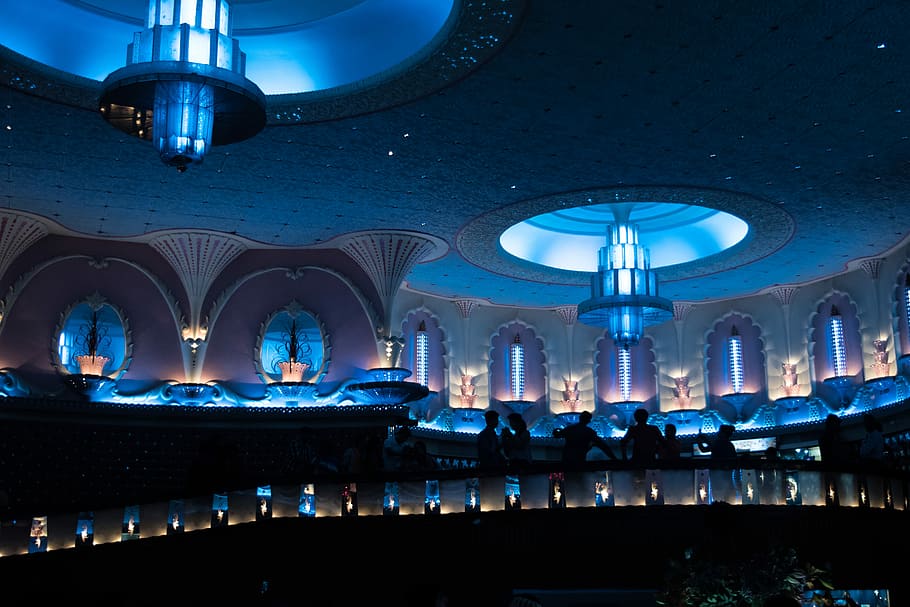 lighted hall with large light fixtures mounted on ceiling, silhouette of people on terrace HD wallpaper