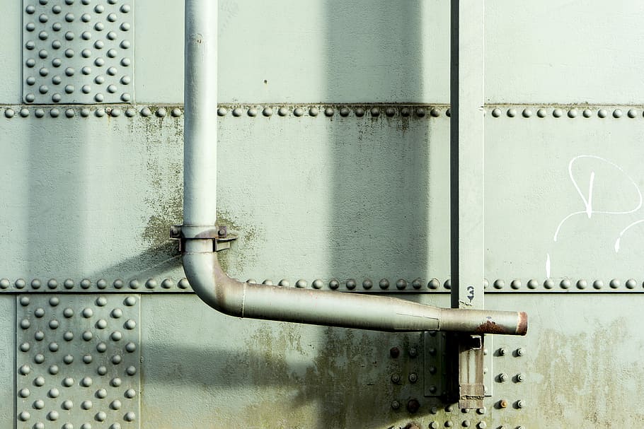 white steel water pipe during daytime, white steel pipe beside steel wall