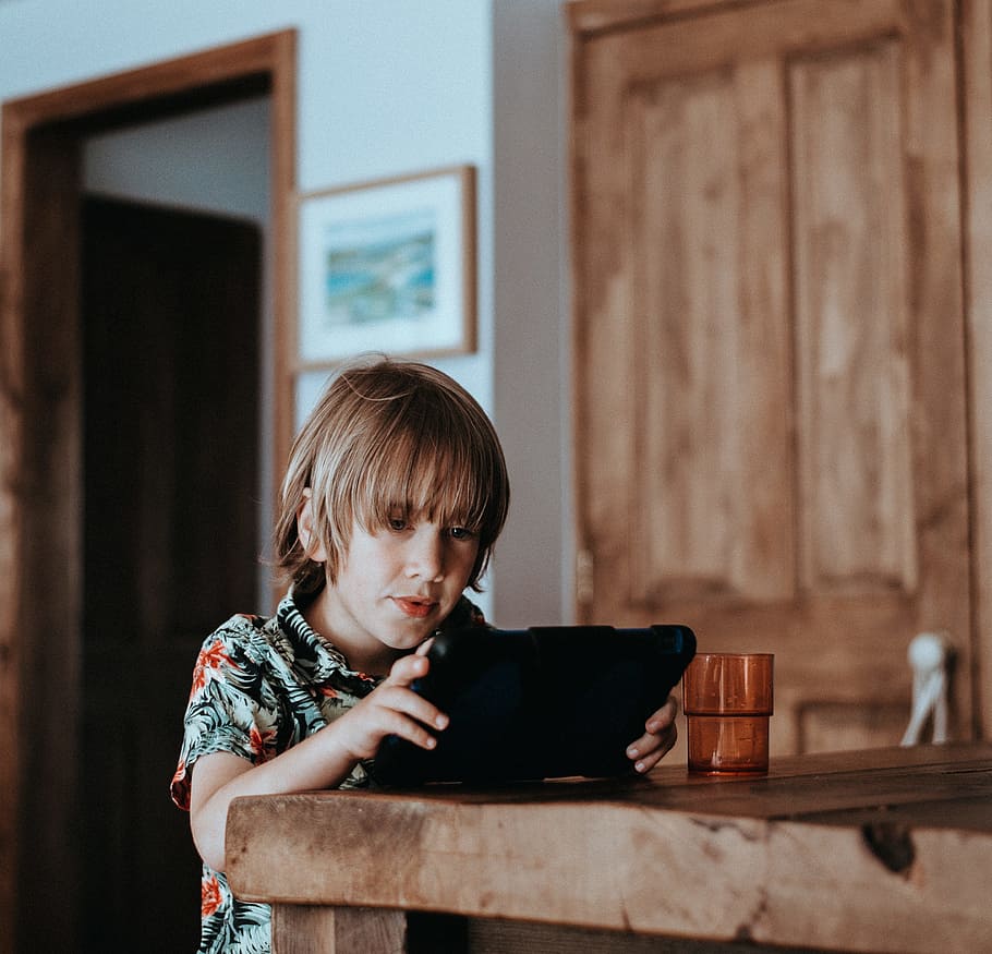 selective focus of child using tablet computer on table, Child playing on iPad HD wallpaper
