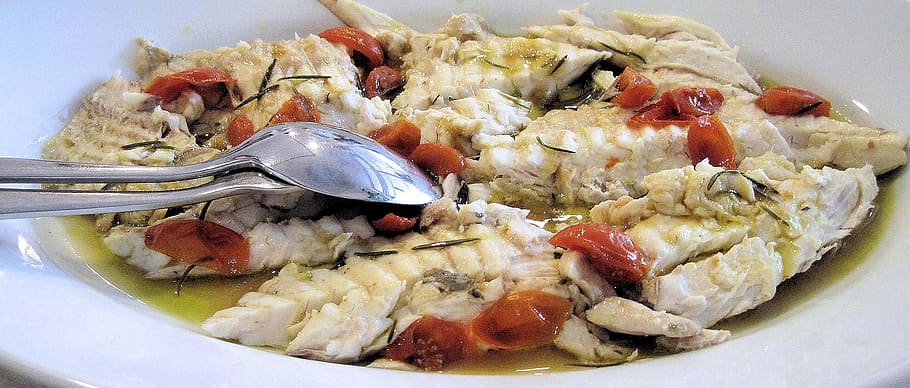 slice fish in white bowl, grilled rombo, tomatoes, herbs, seafood