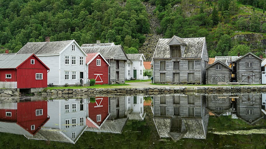 gray, white, and red concrete house reflecting on calm body of water at daytime HD wallpaper