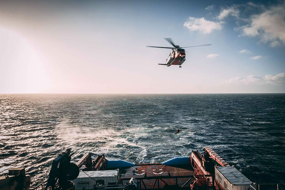 Shetland Coastguard Training, orange helicopter in mid air during daytime HD wallpaper
