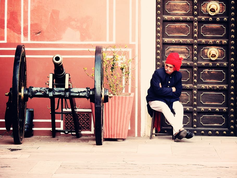 HD wallpaper: man sitting on chair beside vintage cannon on outdoors,  rajasthan | Wallpaper Flare