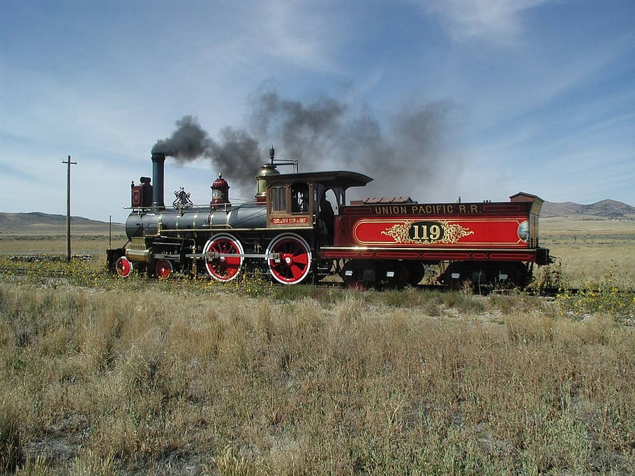 red and black locomotive train near green grass field, steam locomotive