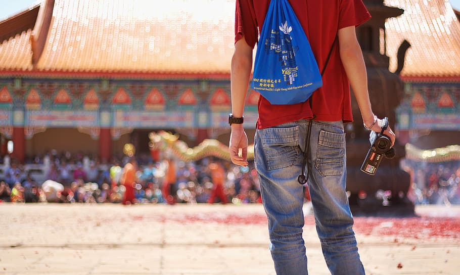 man wearing red shirt holding video camera, blue jeans, guy, male, HD wallpaper