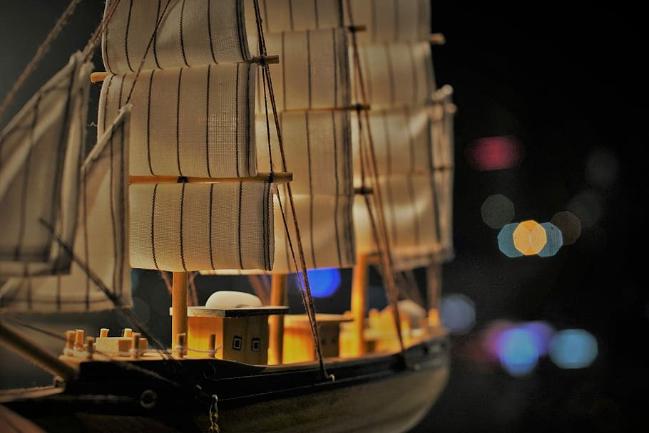shadow depth of field photography of sailboat miniature, closeup photo of brown and black wood ship model with bokeh background HD wallpaper