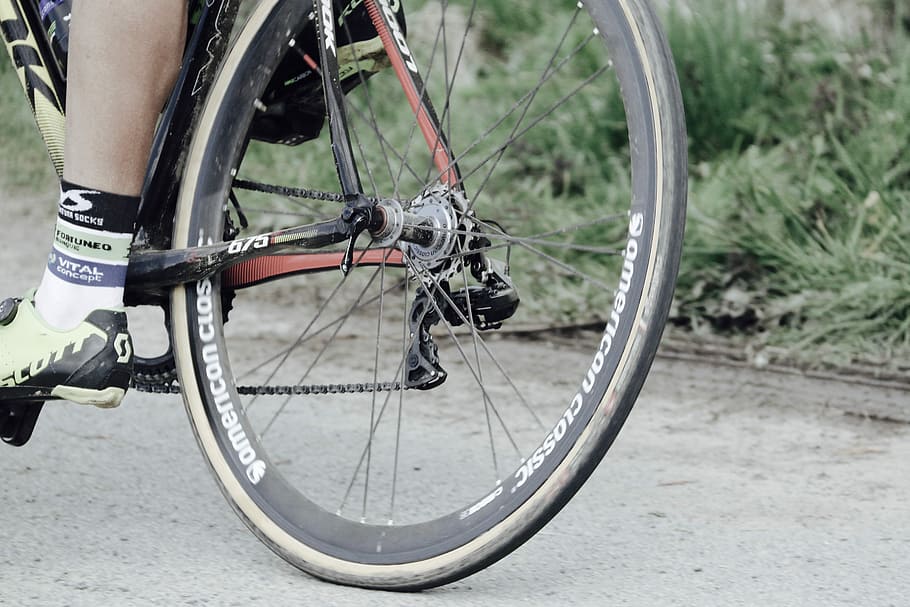 person riding black bicycle, selective focus photograph of bicycle's tire, HD wallpaper