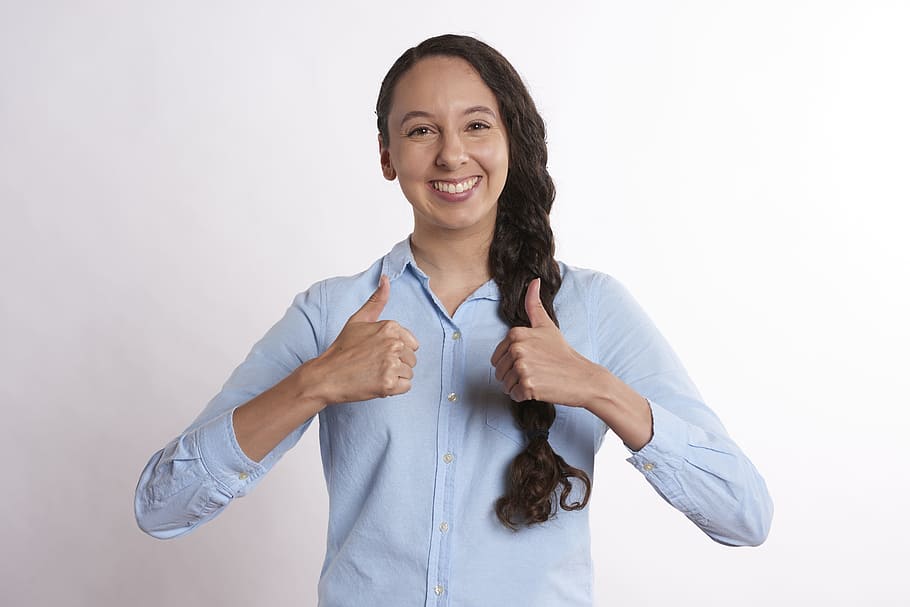 woman doing thumbs up sign near white wall, young, people, isolated