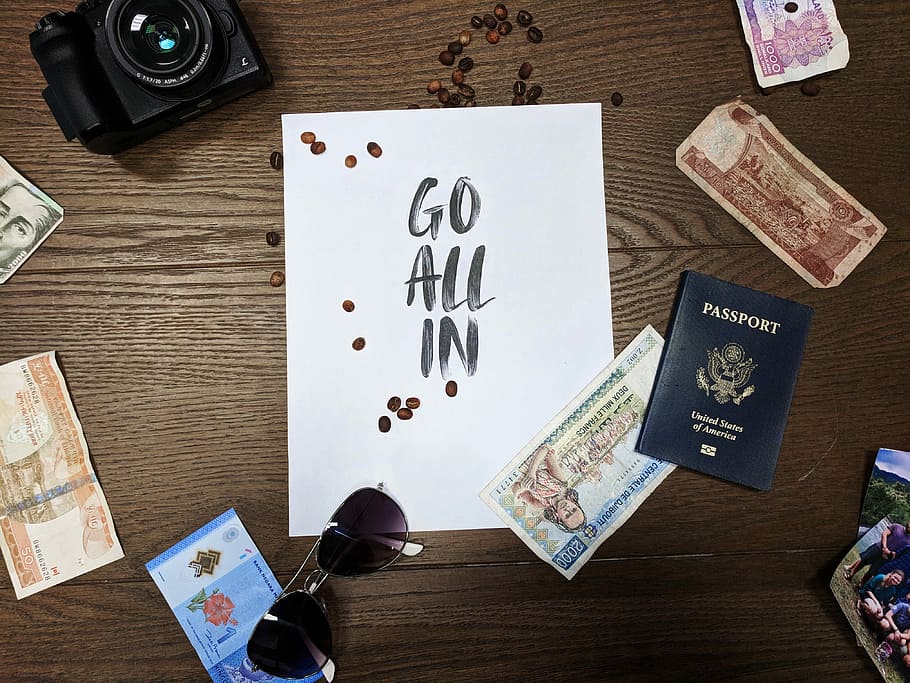Go All In signage in middle of camera and banknotes, Go All in text on white paper sheet beside, banknotes, aviator-style sunglasses, and black bridge camera on brown wooden desk, HD wallpaper
